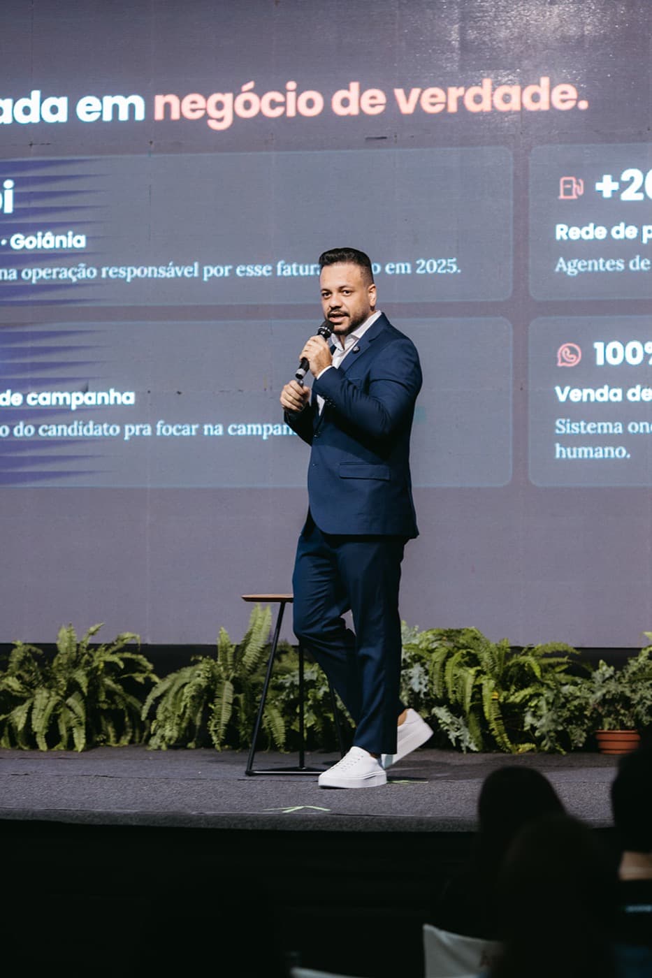 Anderlan Oliveira em pé no palco durante apresentação